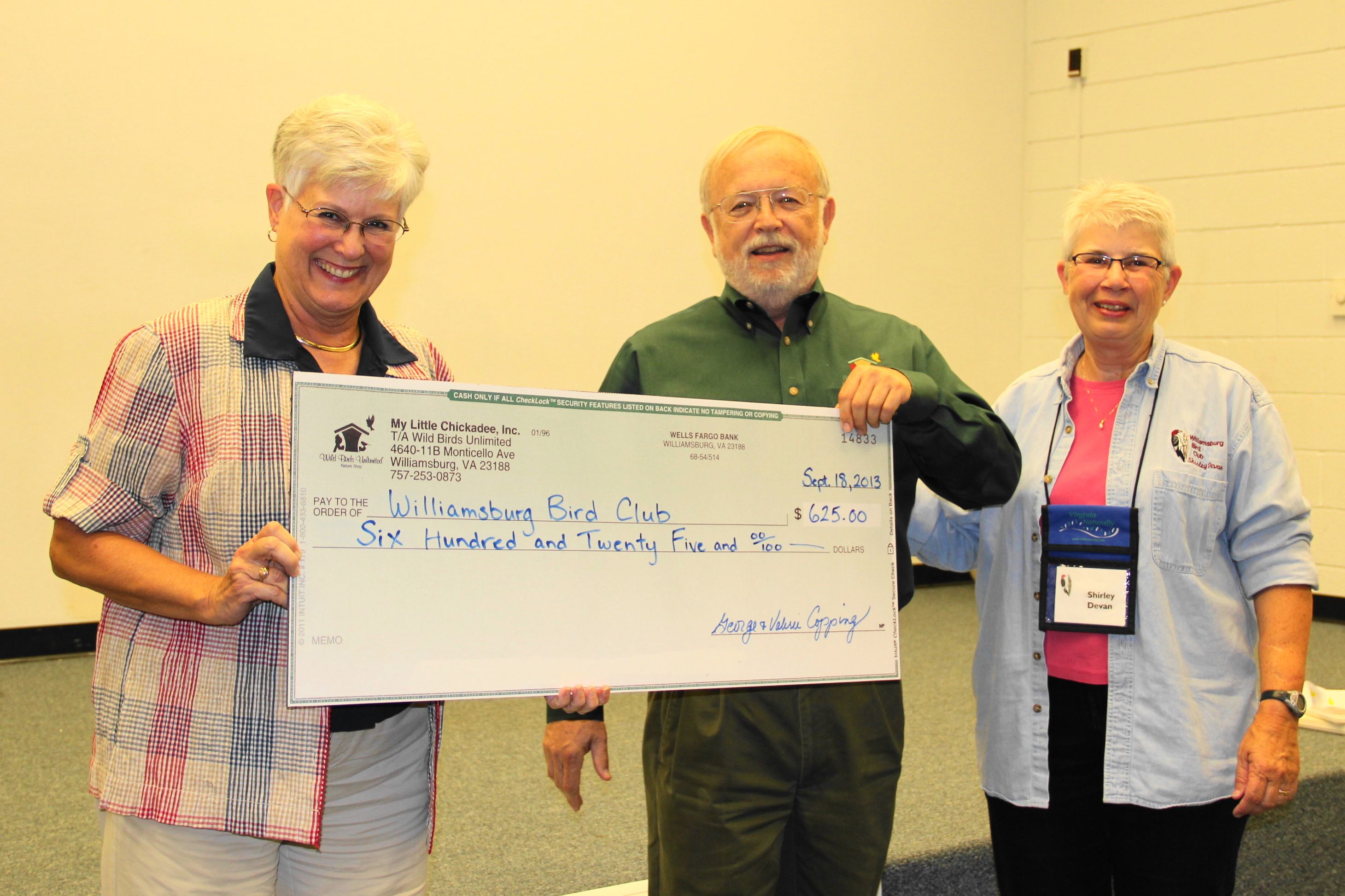 George Copping of Wild Birds Unlimited at Monticello Marketplace presents a check for $625 to Williamsburg Bird Club Treasurer Ann Carpenter (left), and President Shirley Devan during the September club meeting