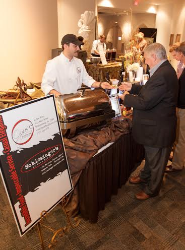 Aaron Guzik, sous chef at Opus 9 Steakhouse in Williamsburg, dishes up corned beef hash for an attendee at The Mariners’ Museum’s March 8 History Bites event (Submitted)