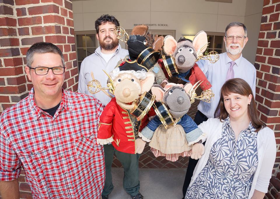 Emmy winners hold their awards and the puppet characters of the Electronic Field Trip, “The Global Economy.” (L-R) Front: Jorin Hood and Leslie Doiron Clark. Back: Charles White and Michael Durling (Photo courtesy of the Colonial Williamsburg Foundation)