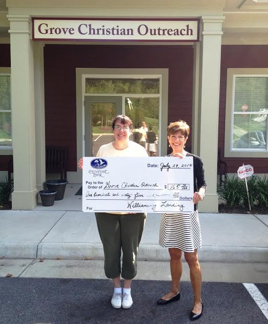 Grove Christian Outreach Center’s Pat McCormick receives a donation from Kathy Kammer, senior director of community relations at Williamsburg Landing (Submitted)