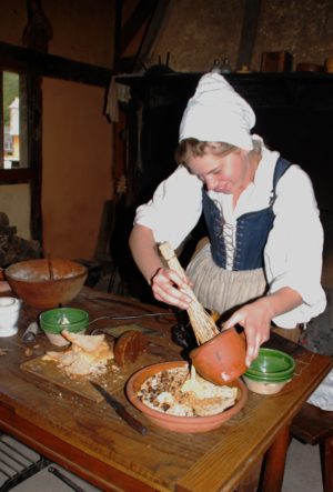 A reenactor makrs bread pudding in Jamestown Settlement's re-created 1610-14 fort, part of the Jamestown-Yorktown Foundation's annual "Food & Feasts of Colonial Virginia" program (Jamestown-Yorktown Foundation photo)