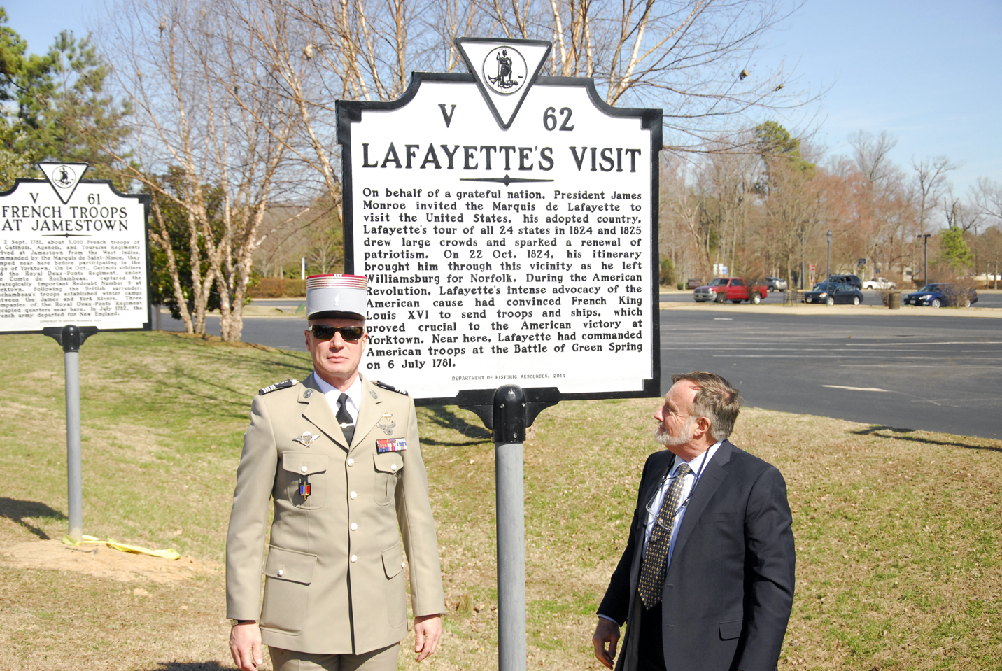 Col. Philippe Roux (left) of the French Army and Alain Outlaw of the James City County Historical Commission pose next to an new historical highway marker at its unveiling ceremony on Wednesday. (Gregory Connolly/WYDaily)