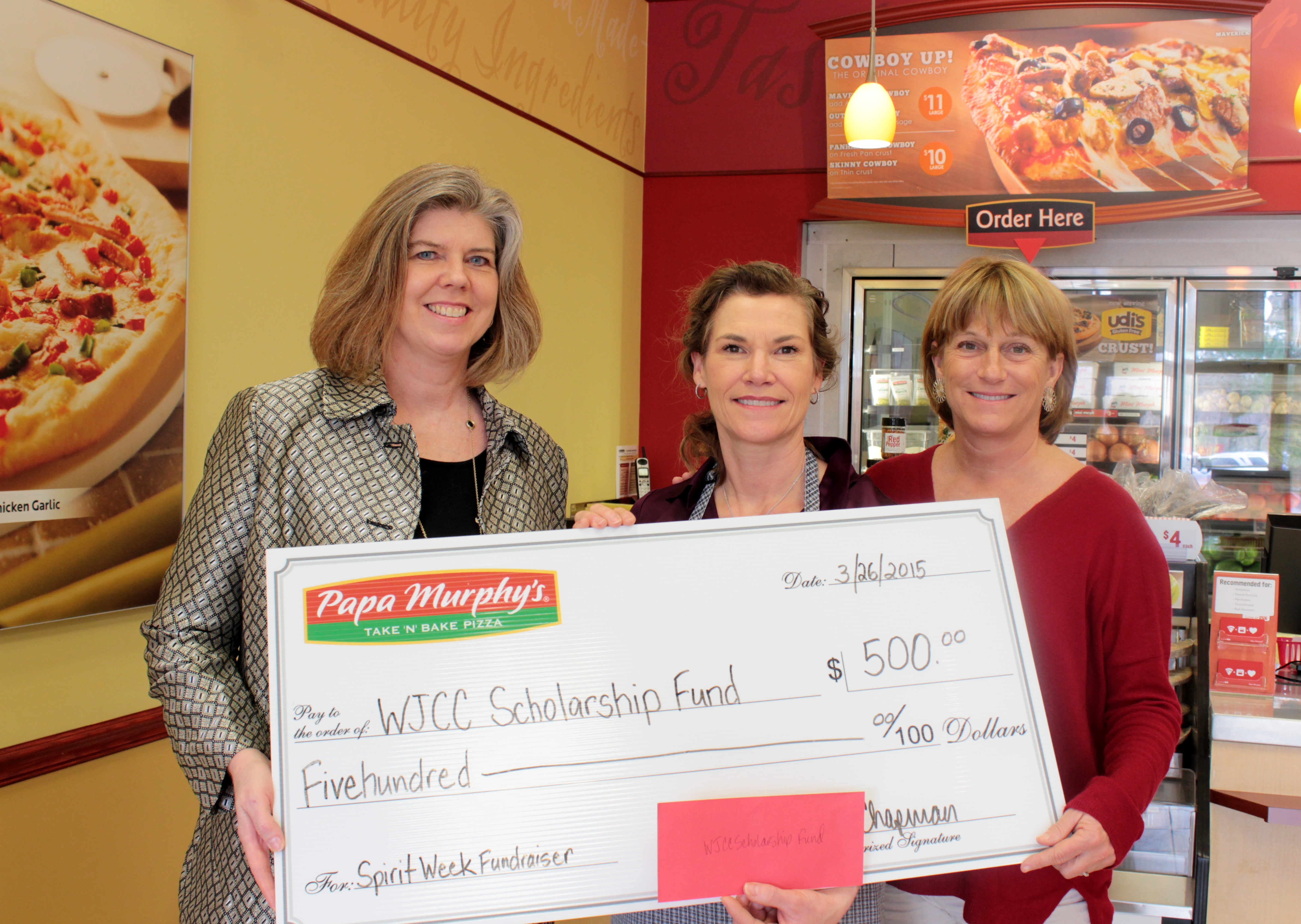 Nancy Sullivan (left), executive director of the Williamsburg Community Foundation, and Kathy Hornsby (right), W-JCC Scholarship Fund committee member, accept a $500 check from Monica Chapman (center), owner of Papa Murphy's pizza. (Courtesy Williamsburg Community Foundation)