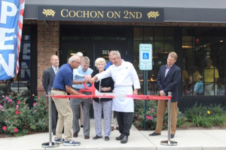 Mayor Clyde Haulman handed off the scissors for Cochon on 2nd's ribbon-cutting to owner Neil Griggs, who asked his parents to help him make the ceremonial cut. (Elizabeth Hornsby/WYDaily)
