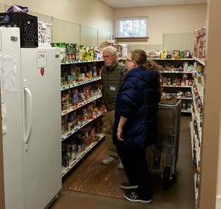 A volunteer assists a client in the Grove Christian Outreach Center's food pantry Nov. 24. (Photo courtesy of Grove Christian Outreach Center)