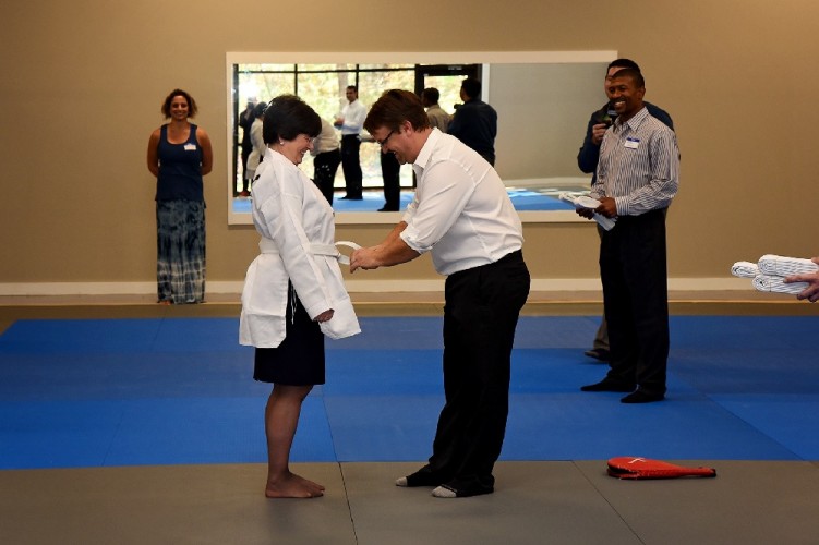 Joseph Ash, owner of Baeplex, helps Greater Williamsburg Chamber & Tourism Alliance President Karen Riordan at the studio's ribbon-cutting. (Courtesy of Baeplex)