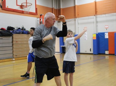 Toano Middle School HPE teacher Ron Trainum practices a stretch with with seventh-grader Cooper Edwards Feb. 18, 2016. (Kirsten Petersen/ WYDaily)