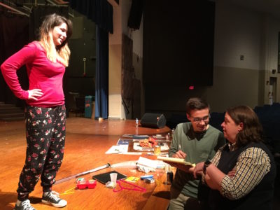 York High School theater teacher Amy Insley, right, and sophomore Parker Dayton go over notes with senior Destiny Delaigle for the upcoming performance of "Footloose."