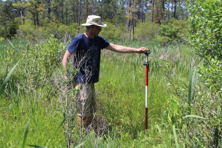 Senior Staff Archeologist Danny Schmidt takes water level measurements in the nearby swamp to determine when the team will hit water in the well. (Elizabeth Hornsby/WYDaily)