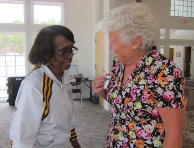 Williamsburg voter Doris Bixler received an "I Voted Today" sticker from Esterine Moyler, an officer of election who has worked at the polls for 33 years. The City of Williamsburg has also experienced low turnout today with only 328 people voting at the Williamsburg Community Building as of 2 p.m. There are 11,000 registered voters in the city. (Kirsten Petersen/ WYDaily)