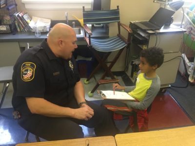 Matthew Whaley Third grader Braylon Love interviews Senior Firefighter Douglas Bailey. (Courtesy Eric Stone.)