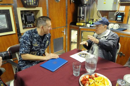 Jim Salvatore swaps Navy stories with Cmdr. Burt Canfield, commanding officer of USS John Warner. (Photo courtesy of U.S. Navy Chief Mass Communication Specialist Darryl Wood)