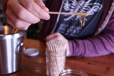 Honey is one of the main ingredients used in making mead. Here, Glen Lavender shows the golden color of one type of honey the meadery uses. (Sarah Fearing/WYDaily)