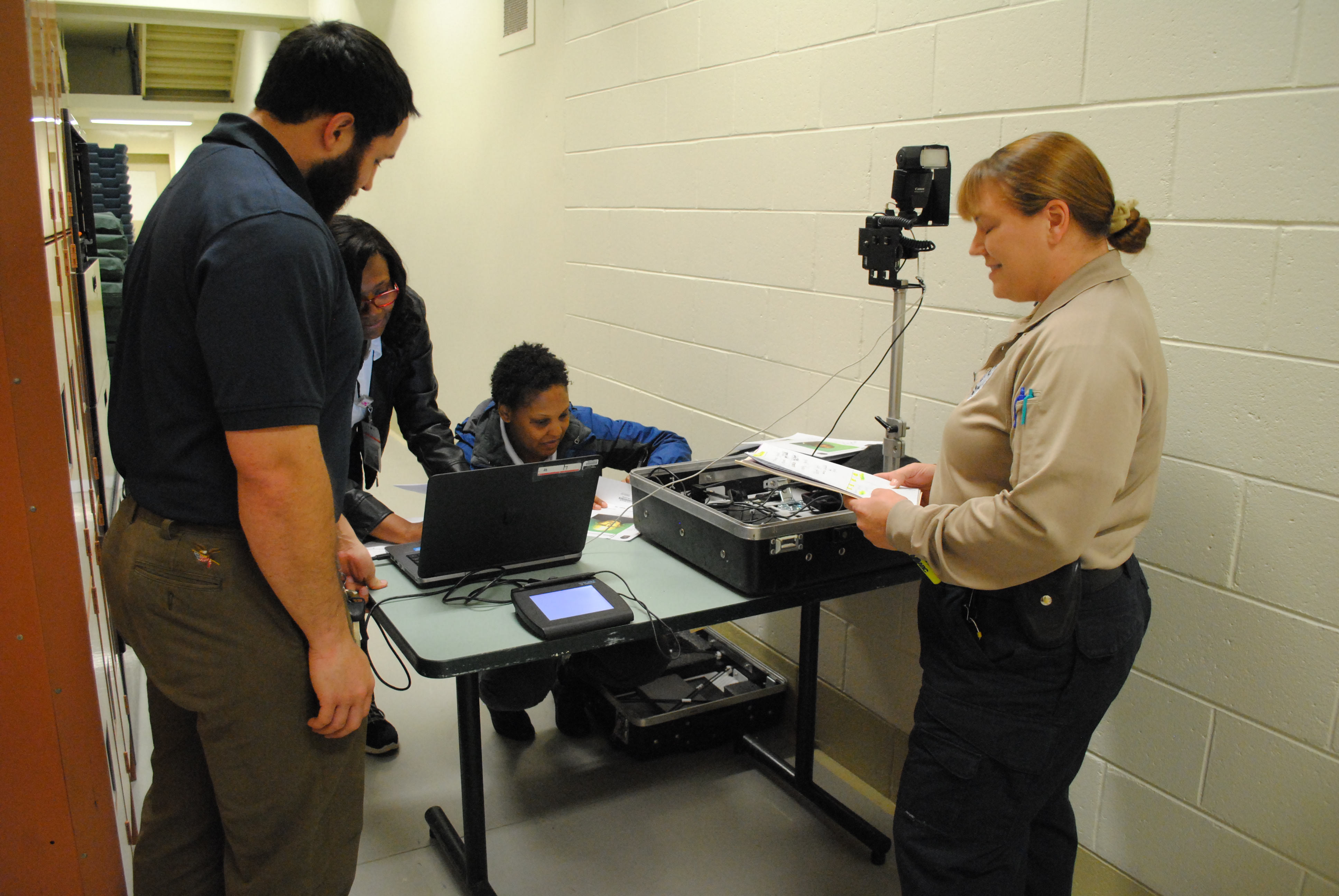DMV employees Eddie Chandler, Jeraye Booth and Latasha Hill set up a mobile ID card station at the Virginia Peninsula Regional Jail. Cpl. Christina McCain (right) runs the program at the jail. (Sarah Fearing/WYDaily)
