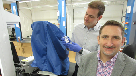 Hannes Schniepp (front) and Sean Koebley have helped to unravel the mystery of what makes the silk of the brown recluse spider particularly strong. Koebley holds a jar contain one of the hundred-odd specimens of the spider in their ISC 3 lab. Photo by Joseph McClain