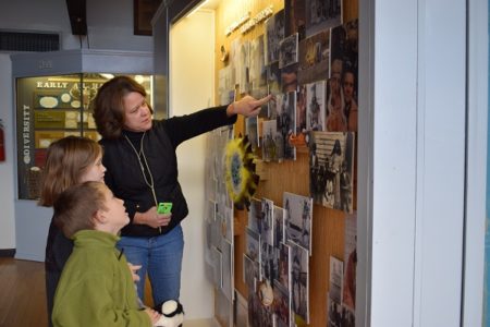 Pamunkey woman Kim Cook Taylor shows young visitors a collage of past and present members of the Pamunkey Tribe. Photo courtesy Ben Swenson