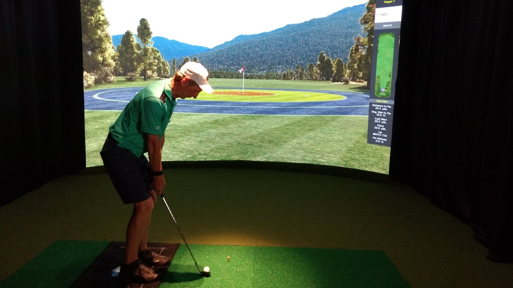 John Holt takes professional golf lessons in his free time. He stepped in one of Revolution Golf and Grille's HD Golf Simulators to practice his swing. (Andrew Harris/WYDaily)