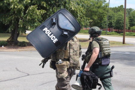 Police armed with riot gear arrive on the scene. They moved through the parking lot of Hardee's, located across second Street from Ebby's. (WYDaily/Andrew Harris)