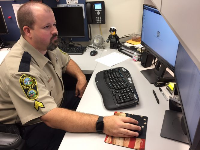 Sgt. Adam Cooper works from his office at the York-Poquoson Sheriff's office June 28. (Sarah Fearing/WYDaily)