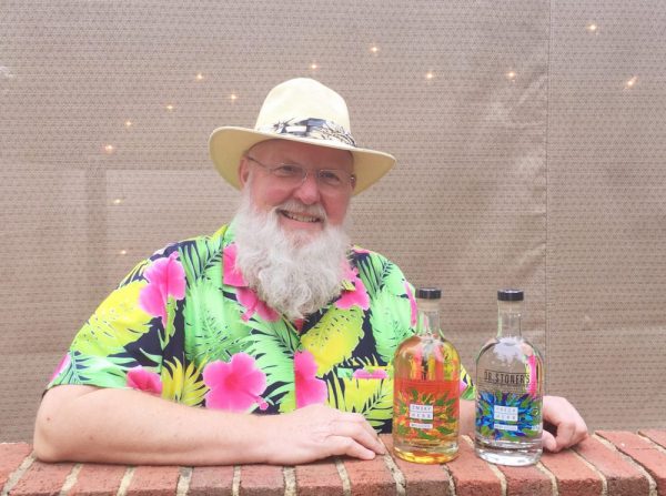 Dr. Craig Stoner and bottles of his herb-flavored vodka and whiskey. (Photo courtesy of Dr. Craig Stoner.)
