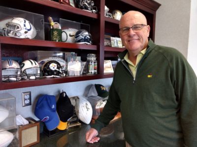 Coach Jimmye Laycock poses alongside a miniature Pittsburg Steelers helmet. Laycock said he's become a fan of the team ever since William & Mary graduate Mike Tomlin took over as had coach. (Andrew Harris/WYDaily)