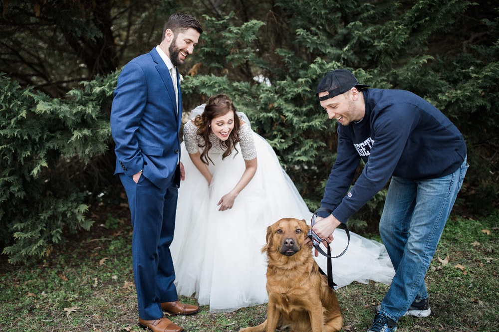 Matt and Mara Dudley are two dog lovers. During the photo session after their wedding, a stranger walked by with his dog. The newlyweds called him over and posed with the dog. (Courtesy Daniel Gorman)
