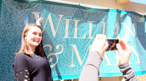 A prospective student points to her name on a banner at last year's Day for Admitted Students. (Stephen Salpukas/W&M News)