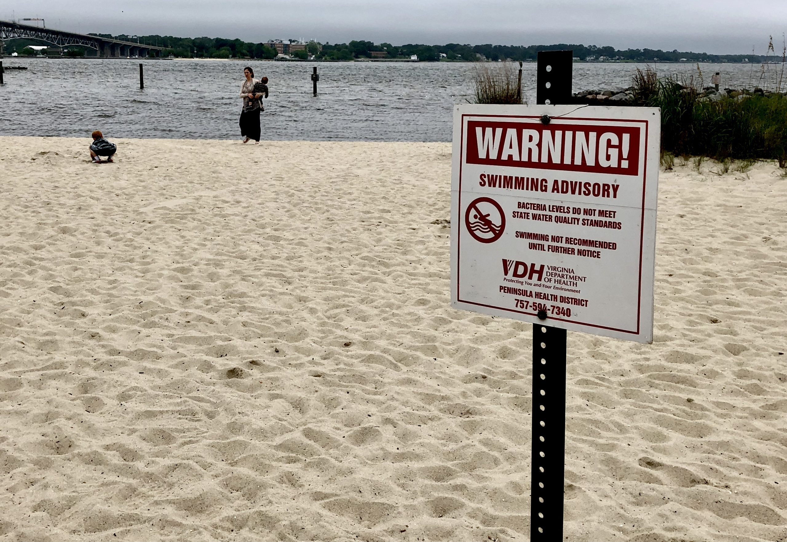 Signs posted on Yorktown Beach warn against swimming in the York River. (Bryan DeVasher/WYDaily)