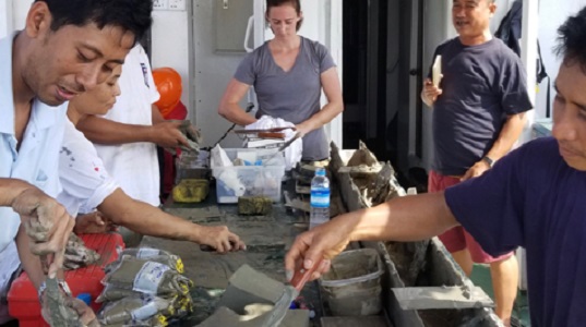 VIMS lab manager Mary Goodwyn (center) joins with colleagues from Myanmar aboard the research vessel Sea Princess to process a sediment core taken from the seafloor of the Andaman Sea.