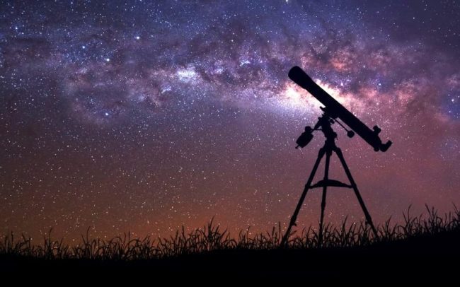 Photo of a telescope against a night sky