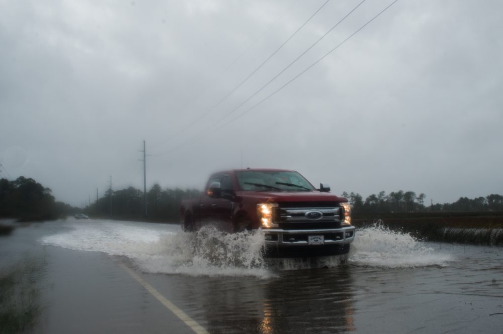 A truck drives through a flooded section of River Road near the Cape Fear River, Saturday, Sept.15, 2018. (Port City Daily photo | Mark Darrough)