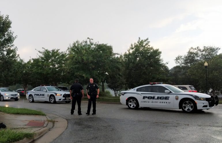 James City County Police officers stand on Noland Boulevard blocking traffic while emergency crews secure a hazmat situation in a postal service vehicle on Aug. 30, 2018. (WYDaily/Sarah Fearing)