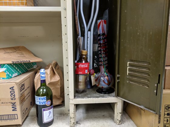 A mostly-full bottle of Barefoot Cabernet Sauvignon covered in &ldquo;evidence&rdquo; tape sits on the floor next to an 18-inch-tall &ldquo;bong.&rdquo; (WYDaily/Sarah Fearing)