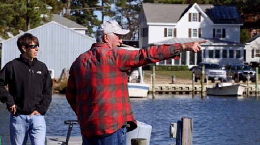 VIMS graduate student Jim DelBene (L) and his professional mentor J.C. Hudgins look over the water along a dock on Gwynn's Island in the Chesapeake Bay. (Southside Daily/A. Devlin/Virginia Sea Grant)