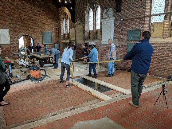 A crew from Jamestown Rediscovery pulls a cart carrying the Knight's Tombstone into the 1907 Memorial Church. (WYDaily/Sarah Fearing)