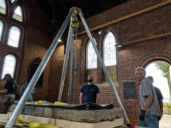Jamestown Rediscovery and Jonathan Appell from Atlas Preservation used a tripod hoist to lift the Knight's Tombstone off a transportation cart and into a permanent setting in the floor of the Memorial Church Tuesday. (WYDaily/Sarah Fearing)