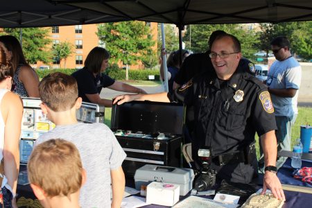 A Williamsburg Police officer stands at an information table at National Night Out Tuesday, Aug. 6, 2019. (WYDaily/Courtesy WPD)