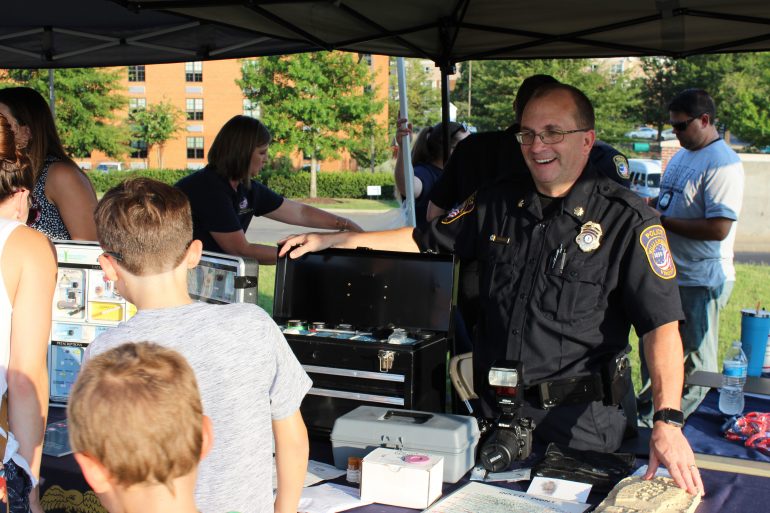 A Williamsburg Police officer stands at an information table at National Night Out Tuesday, Aug. 6, 2019. (WYDaily/Courtesy WPD)