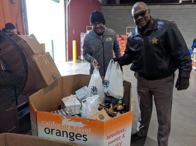 Mayor of Newport News, McKinley Price, and Newport News Sheriff, Gabe Morgan, receive donations at the Virginia Peninsula Foodbank during the annual Martin Luther King Jr. "Day of Service" food drive. (WYDaily/Courtesy Dorothy Wikan)