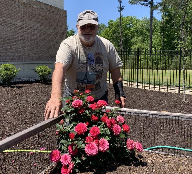 Ed Worley, a resident at the seniors care facility Edgeworth Park, is cutting roses for his wife on Mother's Day. (WYDaily/Courtesy Victoria Bowen)