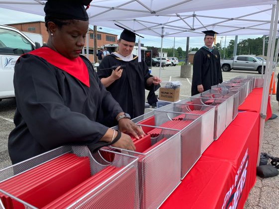 Staff rushed to grab diplomas as cars drove past in a line to drop off students. (WYDaily/Alexa Doiron)