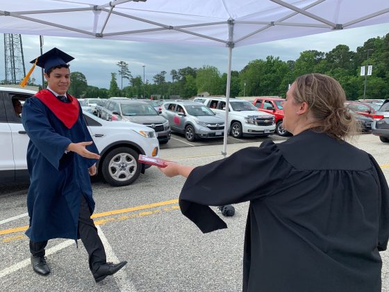 Students stepped out of their cars and received their diplomas which they held as they walked across stage. (WYDaily/Alexa Doiron)
