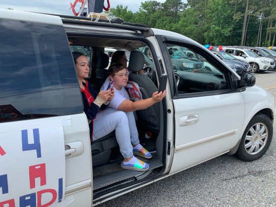 As families drove by the stage, many hung out of car doors and windows to take photos of the graduate. (WYDaily/Alexa Doiron)