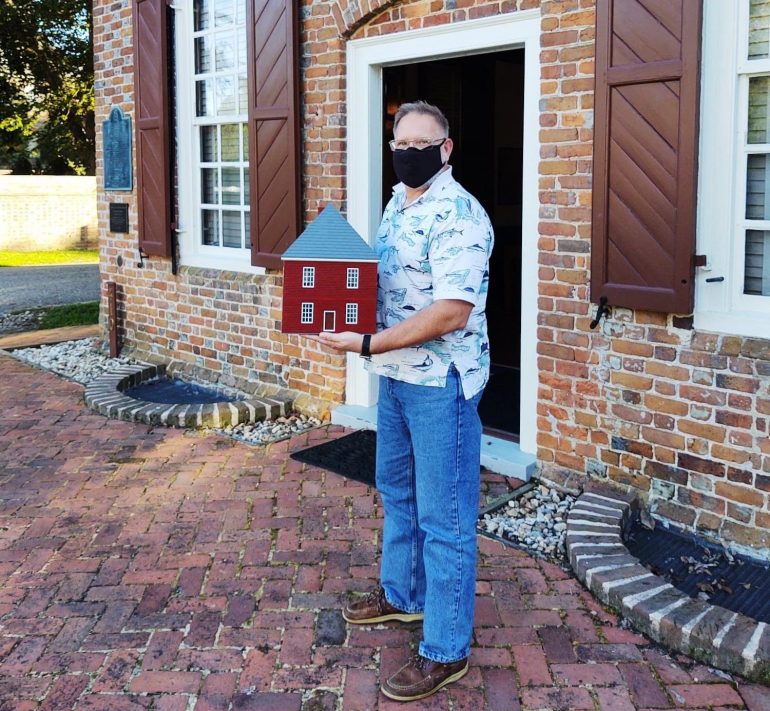 Doc Brick with the Lego Custom House model in front of of actual building. (WYDaily/Courtesy of Visit Yorktown Facebook page)
