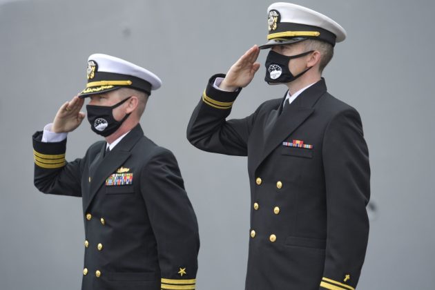 Cmdr. Edward Pledger, commander, USS Cole (DDG 67) and Lt. j.g. Harry Hazell, Chaplin, USS Cole, salutes during the National Anthem at the Arleigh Burke-class guided missile destroyer USS Cole (DDG 67) 20th Anniversary memorial ceremony at Naval Station Norfolk. (U.S. Navy photo by Mass Communication Specialist 2nd Class Darien G. Kenney)