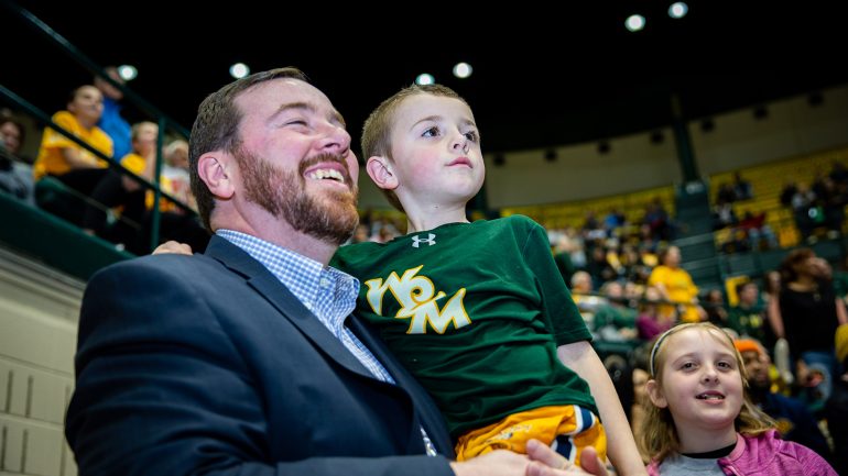 Interim Athletics Director Jeremy Martin watches a W&M basketball game in Kaplan Arena with his two children. (WYDaily/Courtesy of Skip Rowland, W&M News)